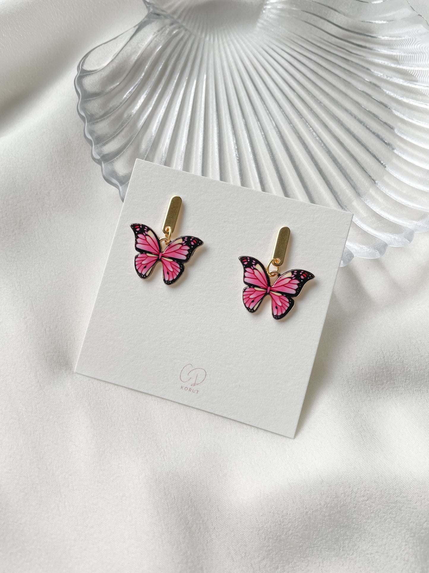 Korvakorut pinkki perhonen